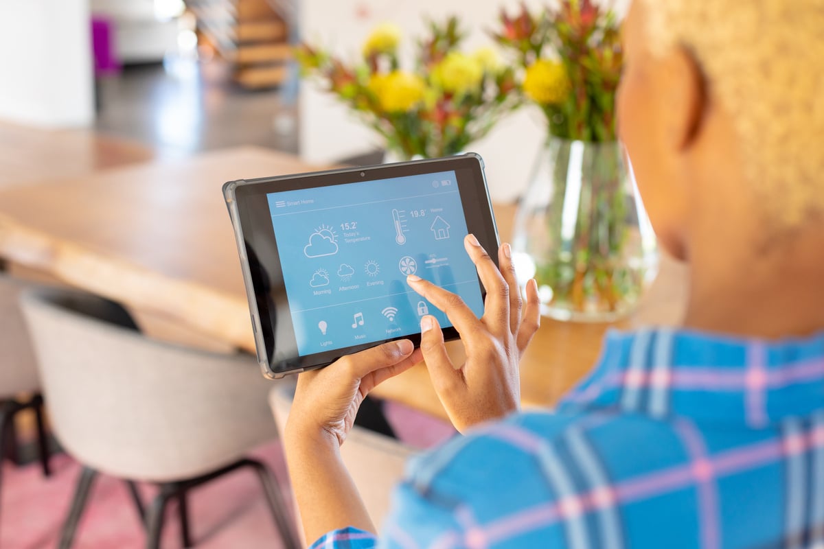 A woman using smart home features on a tablet