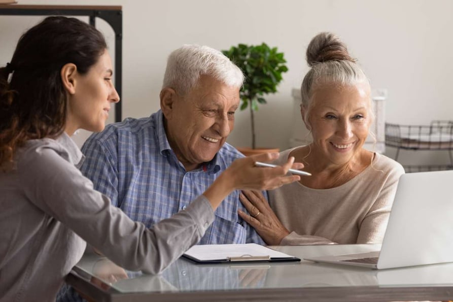 Female banking specialist consult happy mature couple about loan or mortgage at meeting in office