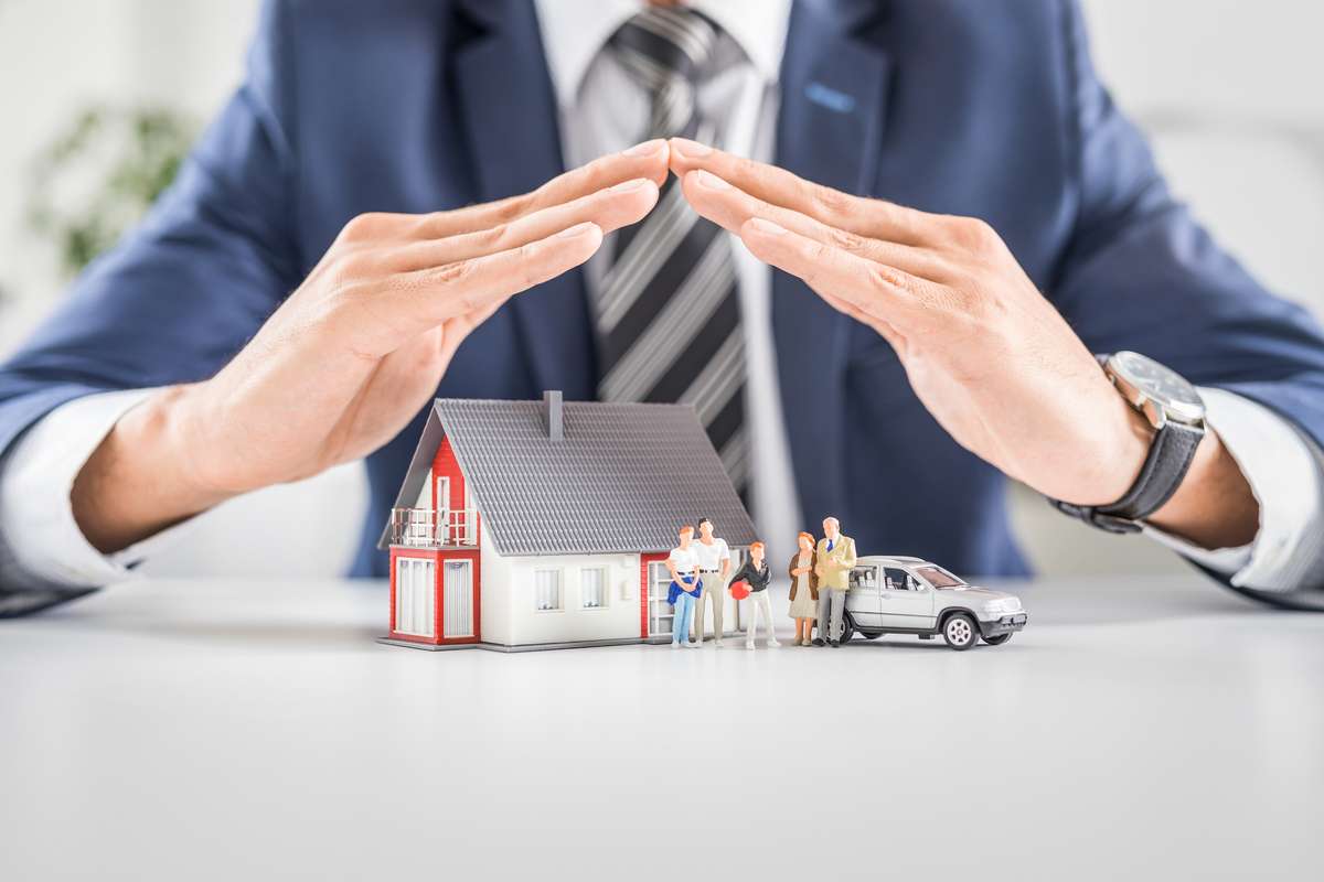 Insurance agent with house toy, safety insurance concept