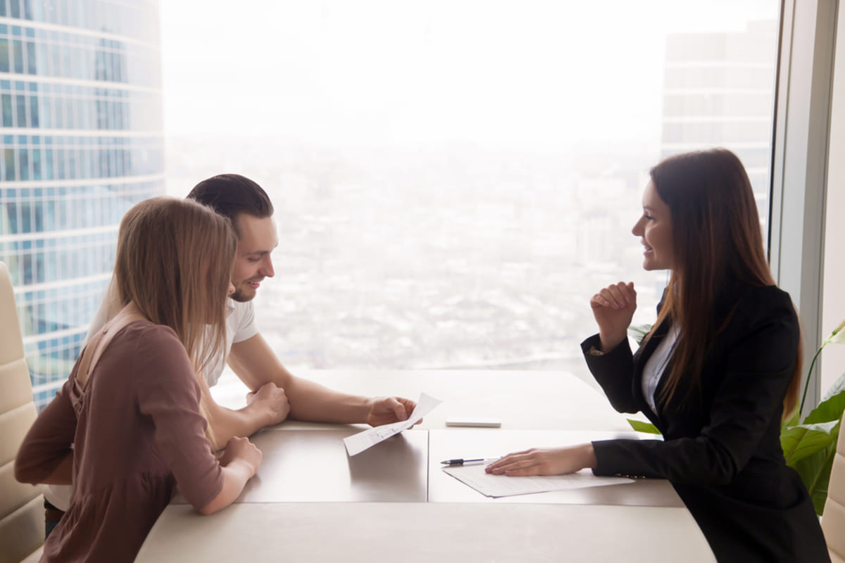 Side view of property manager and landlord couple sitting at office desk desk