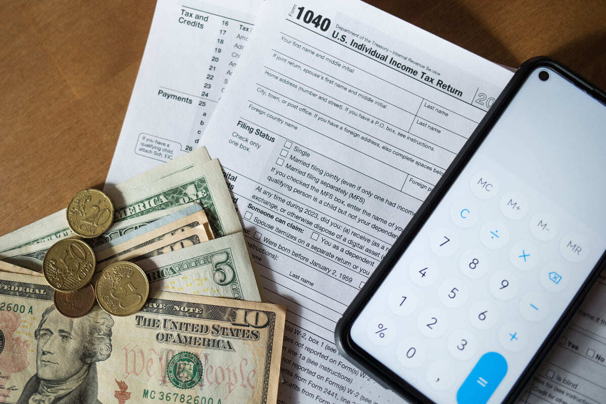 Cash and a calculator on top of a tax return document