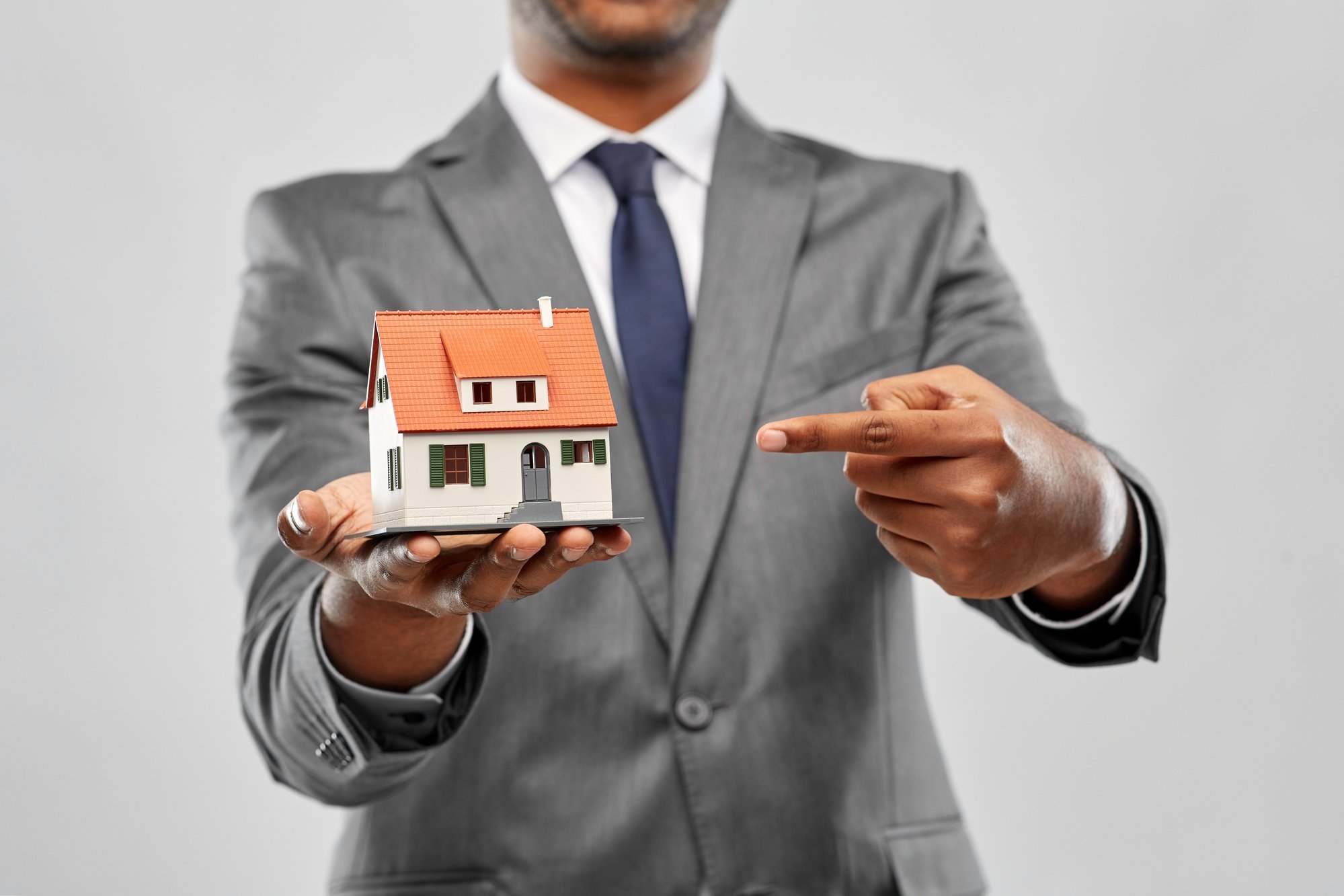 Indian man realtor with house model and folder