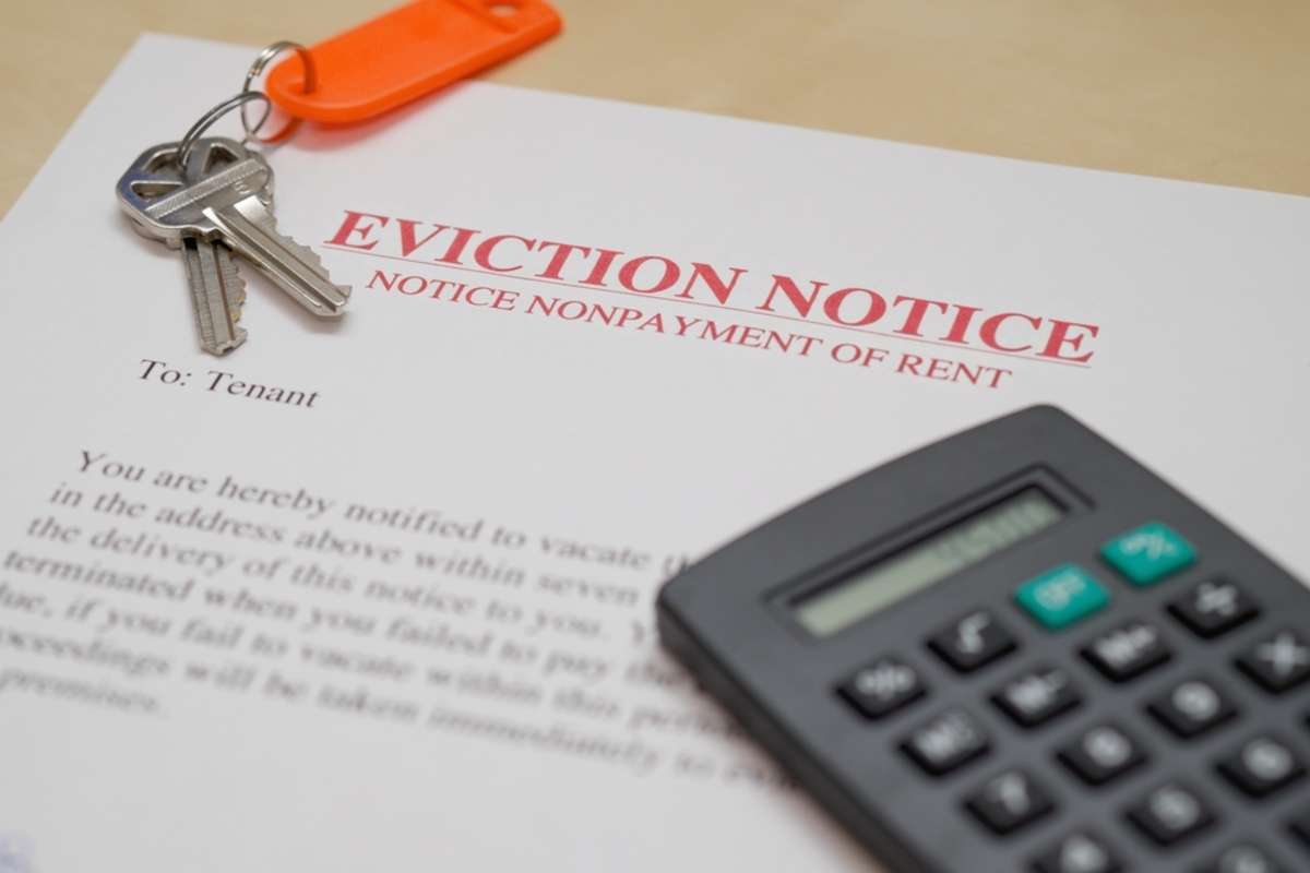 EVICTION NOTICE WITH KEYS AND CALCULATOR IN BACKGROUND