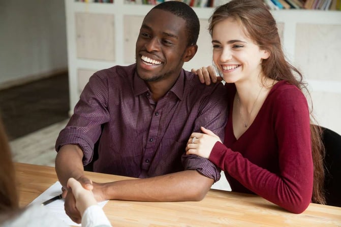 Happy attractive multiracial couple shaking hands with advisor or realtor family mortgage investment