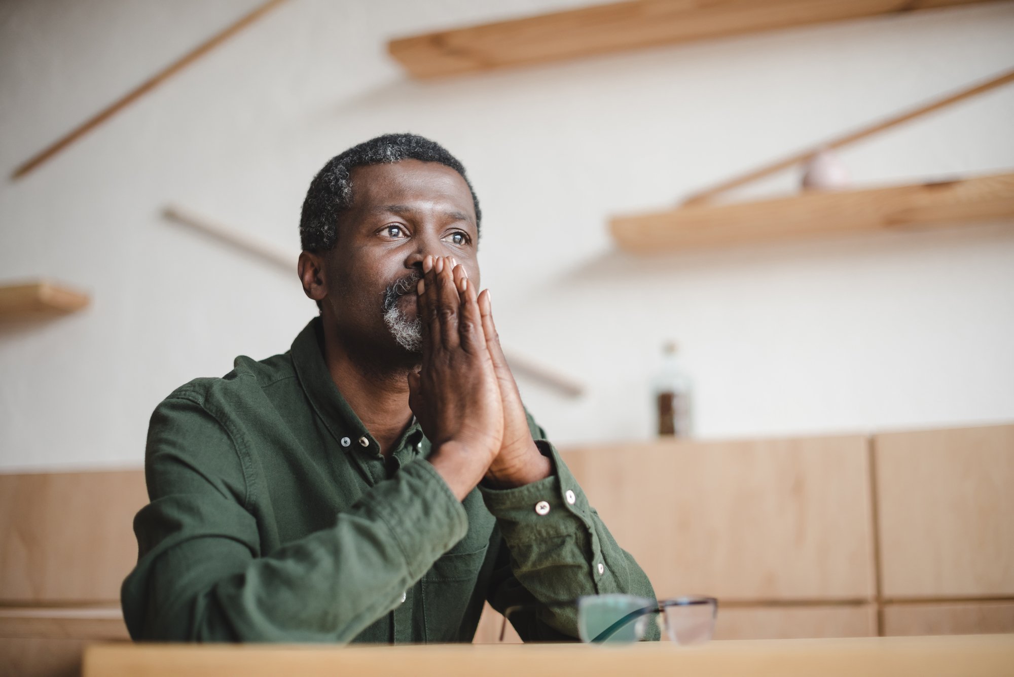 Thoughtful mature man sitting in cafe - stock image