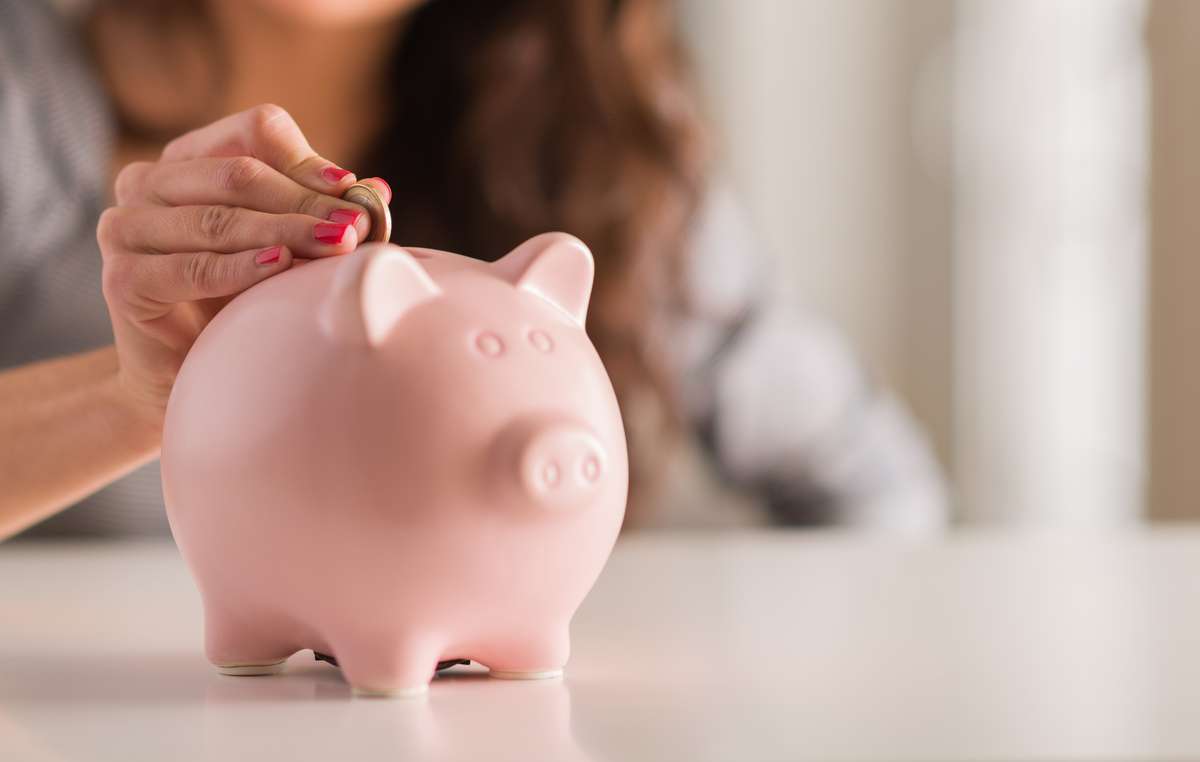 Woman Putting Coin In Piggy Bank (R) (S)