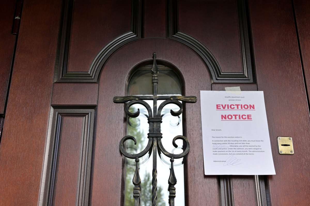 the notice of eviction of tenants hangs on the door of the house, front view