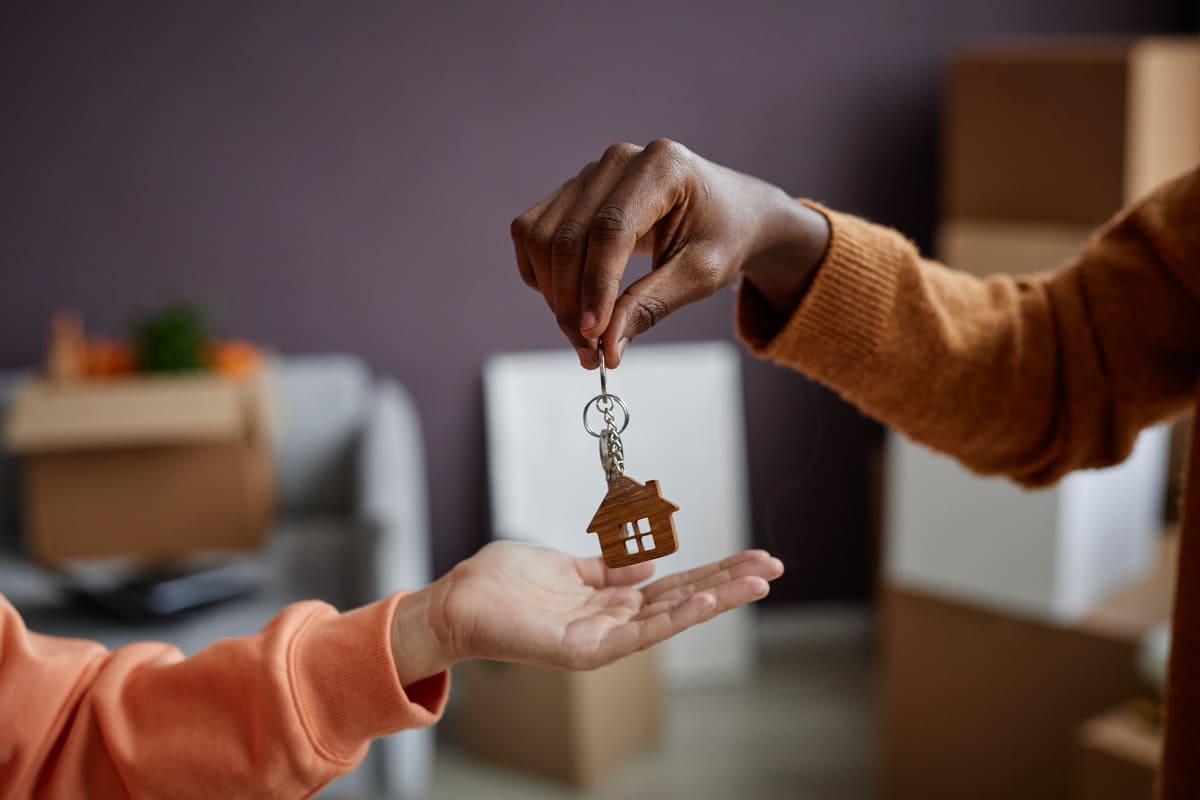 A real estate professional handing a woman keys to a home