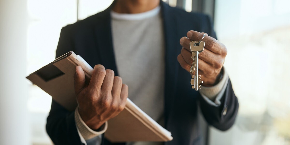 A man holding a folder and keys