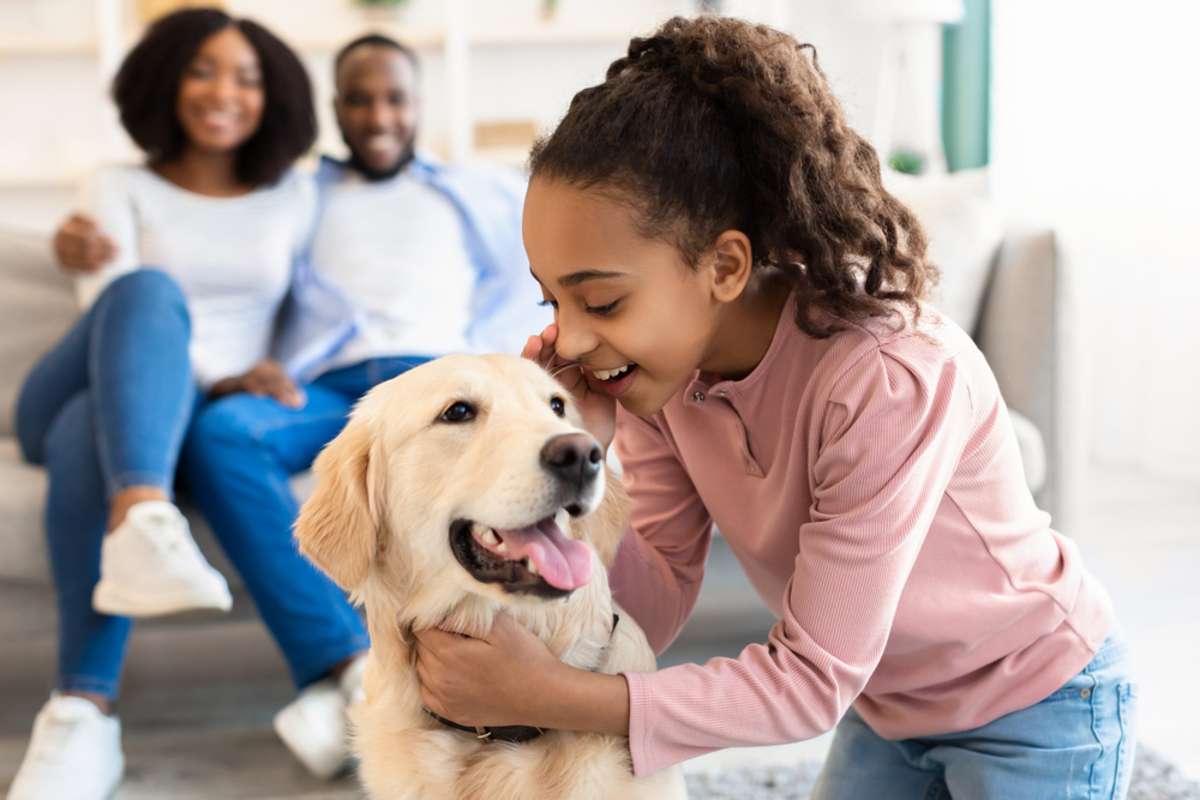 Child playing with dog while parents watch, should I rent or sell my home concept