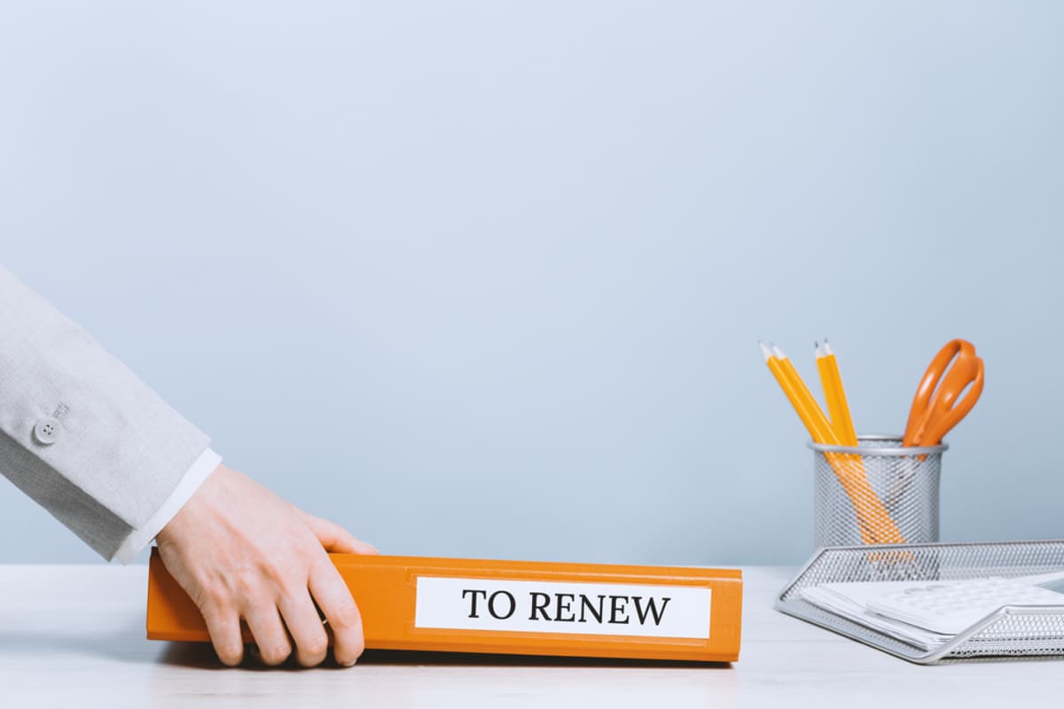 Hands with a binder with "to renew" on it, lease renewal concept