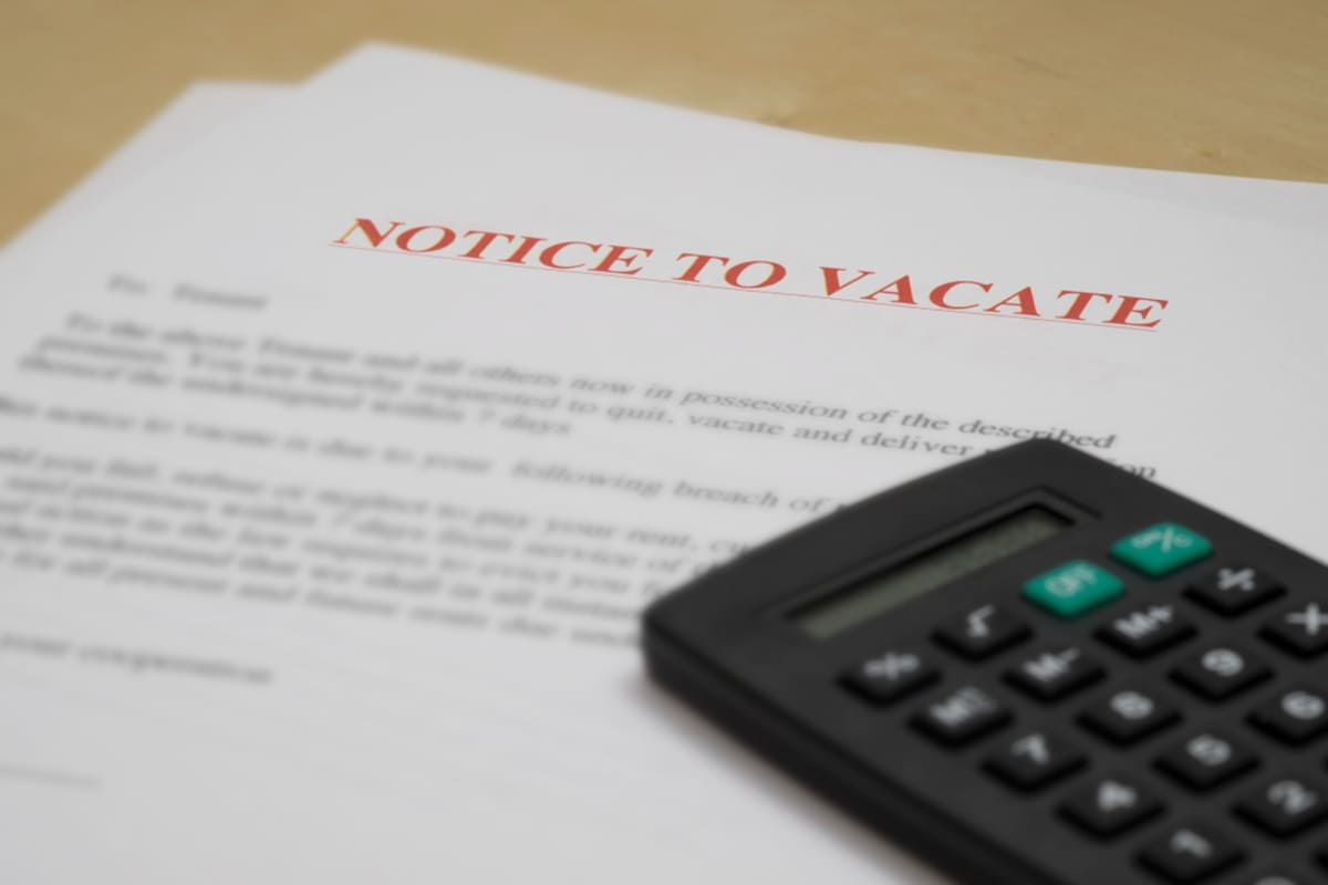 Notice to vacate document and calculator on desk.