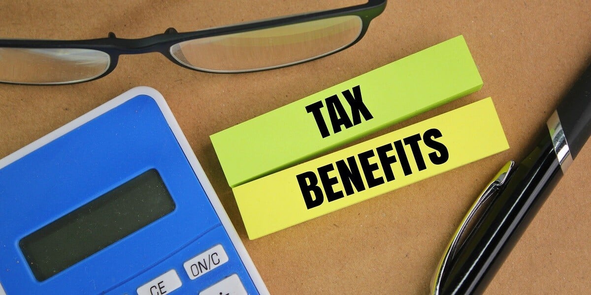 Paper that says tax benefits next to a calculator and pen