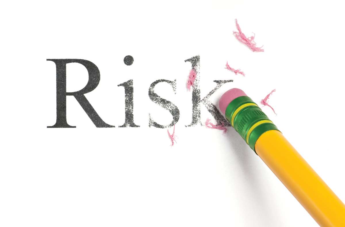 pencil eraser erasing the word Risk