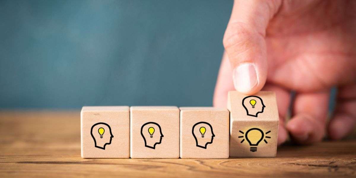 Many people together having an idea symbolized by icons on cubes on wooden background