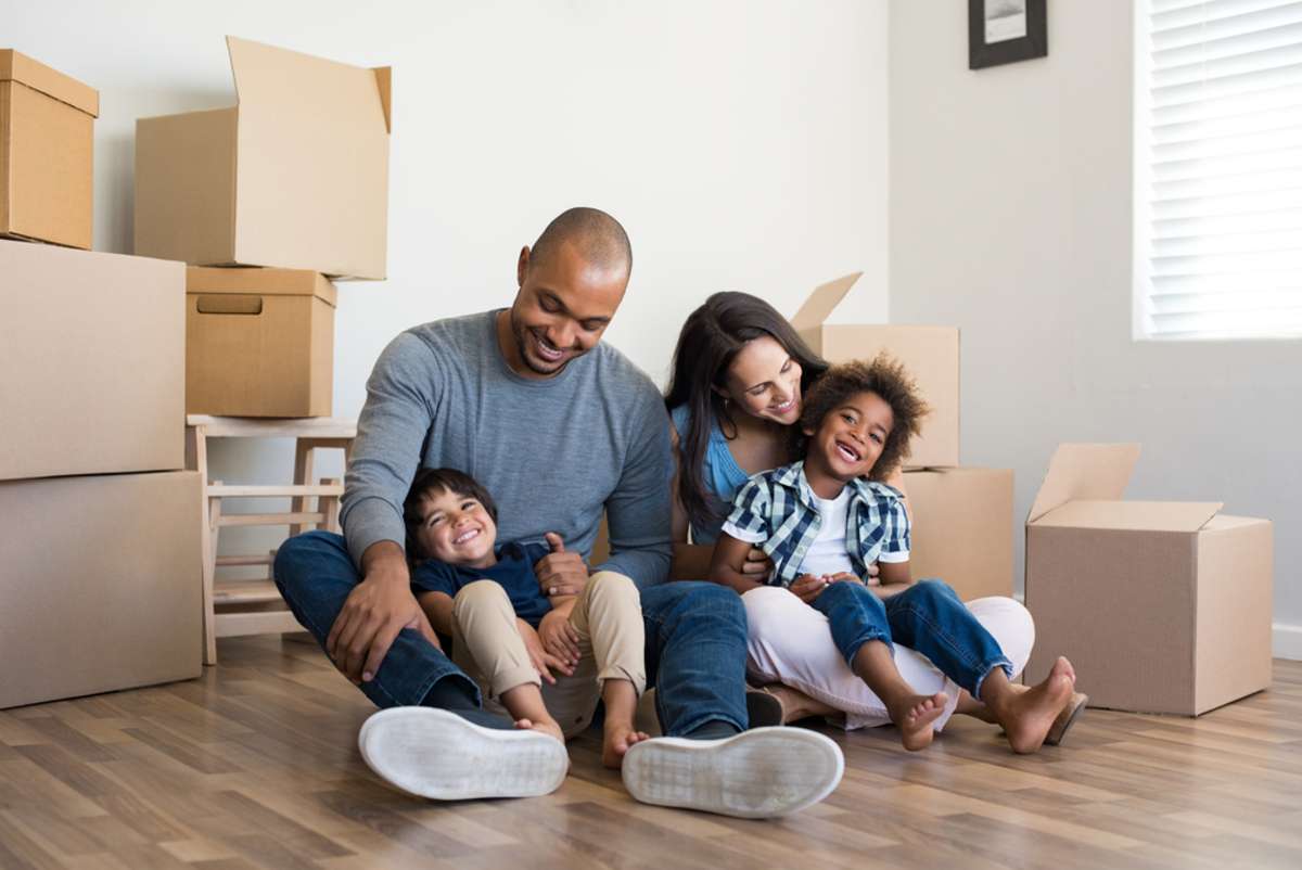 Happy family with two children having fun at new home